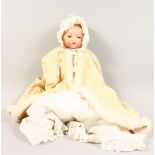 AN ARMAND MARSEILLE BISQUE HEADED DOLL, wearing a bonnet and long gown and coat. Mark: AM,