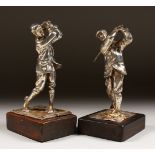 A PAIR OF SILVER GOLFING FIGURES on wooden bases. 6ins high.