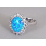 A GILSON BLUE OPAL AND ZIRCON OVAL CLUSTER RING, set in silver.
