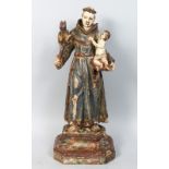 A 17TH-18TH CENTURY ITALIAN CARVED WOOD AND PAINTED STANDING MONK holding a cupid. 20ins high.