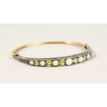 A 9CT GOLD, PERIDOT AND PEARL BANGLE.