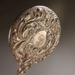 A LARGE HAND MIRROR with repousse scrolls and flowers. Birmingham 1904.