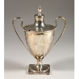 A GEORGE III TWO-HANDLED URN SHAPED CUP AND COVER, with bead edge and reeded handle. 7.5ins high.