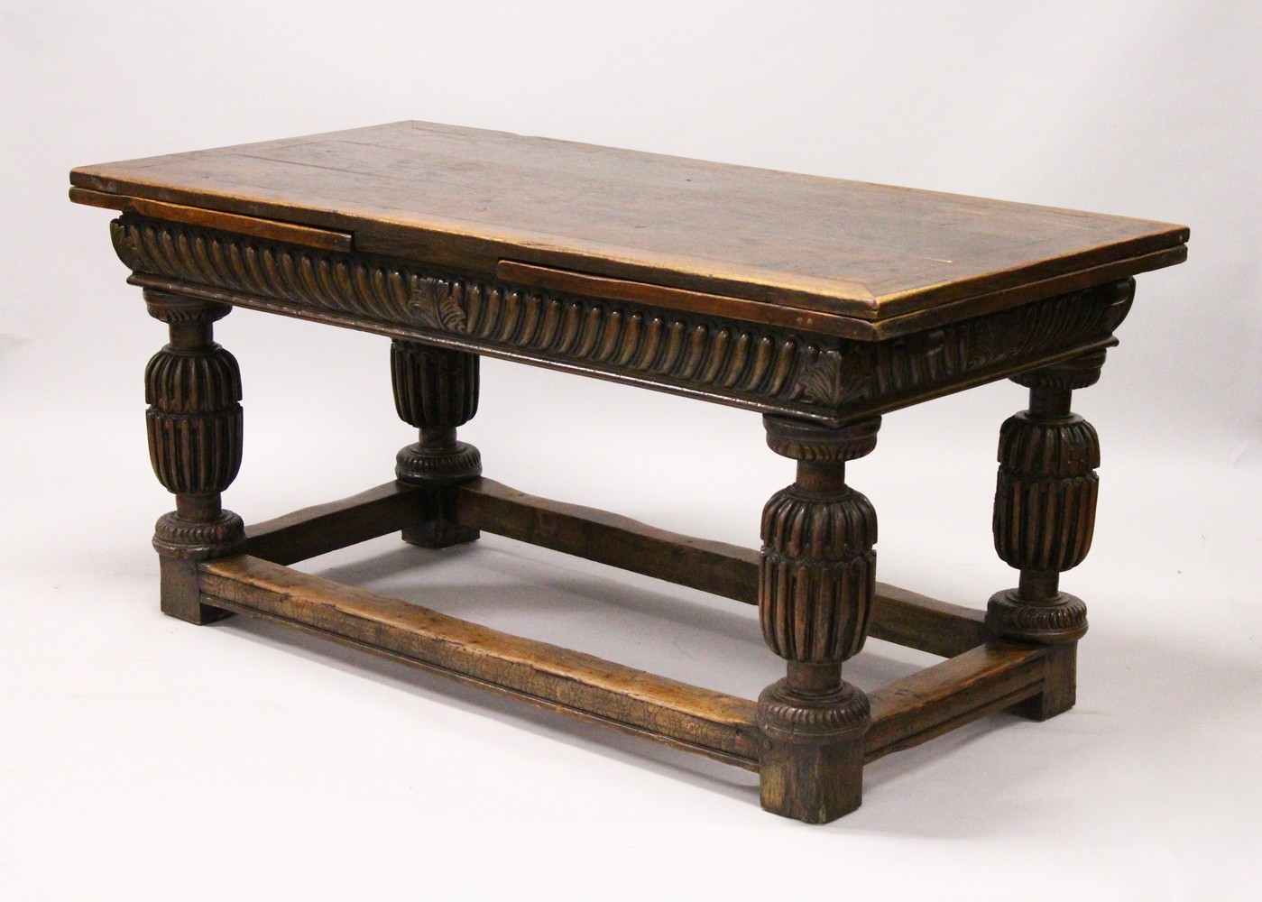 A GOOD 17TH/18TH CENTURY OAK DRAW LEAF TABLE, with a plain rectangular top, carved frieze on four