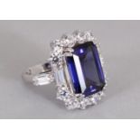 A LARGE SAPPHIRE COLOURED STONE AND ZIRCON CLUSTER RING, set in silver.