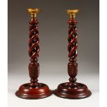 A PAIR OF TURNED WOOD CANDLESTICKS. 12ins high.