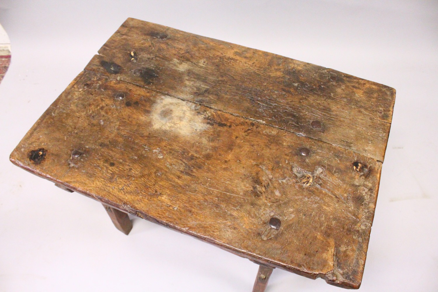 A 16TH CENTURY OAK RUSTIC LOW TABLE, with plank top over a drawer with carved decoration, a circular - Image 2 of 7