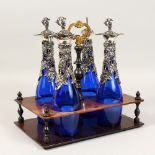 A SET OF FOUR BRISTOL BLUE DECANTERS, with plated fruiting vines, in a wooden carrying case.