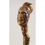 A WALKING CANE, the head with carved Red Indian. 30ins long.