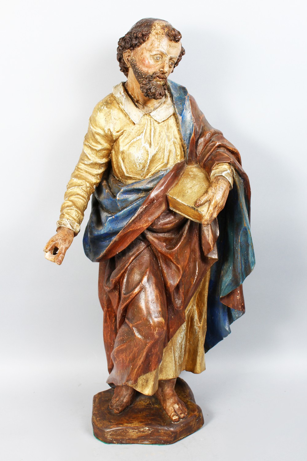 AN 18TH CENTURY DUTCH CARVED WOOD AND PAINTED STANDING FIGURE OF A SAINT holding a book. 34ins