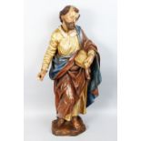 AN 18TH CENTURY DUTCH CARVED WOOD AND PAINTED STANDING FIGURE OF A SAINT holding a book. 34ins