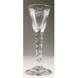 A GEORGIAN WINE GLASS, with facet stem, the bowl engraved with vines and flowers. 6ins high.