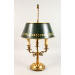 A GOOD TOLEWARE THREE LIGHT LAMP, with green Tole shade, on a circular base.