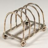 A FOUR DIVISION TOAST RACK on bun feet. Chester 1909.