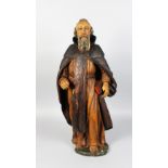 AN 18TH CENTURY CARVED WOOD AND PAINTED FIGURE OF A MAN holding a bible. 30ins high.