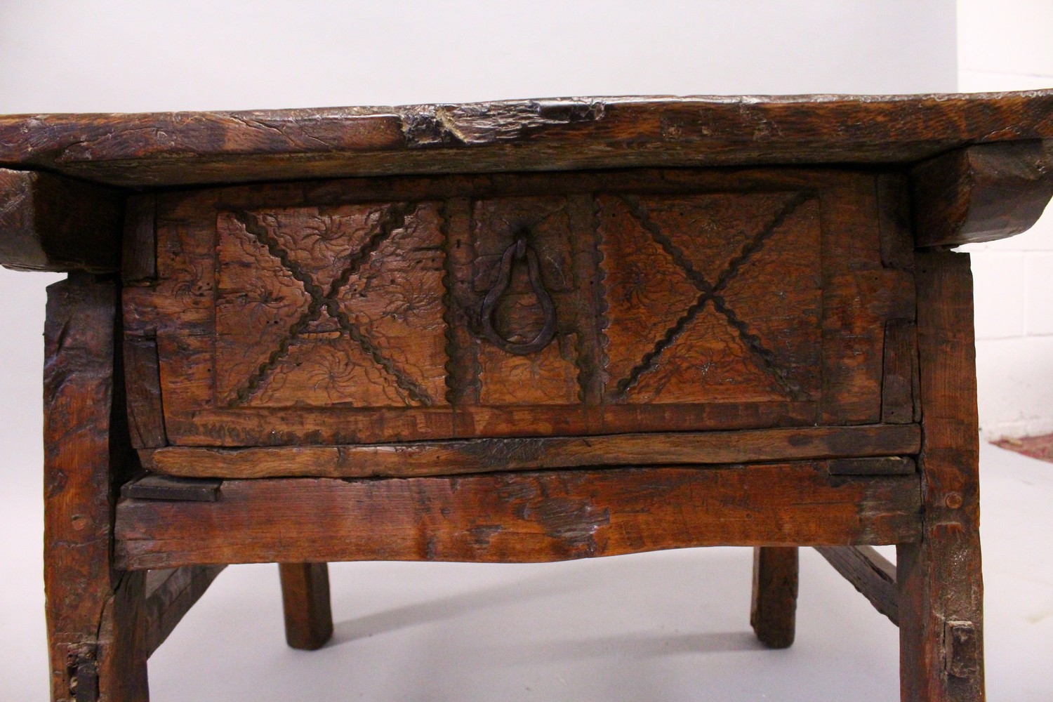A 16TH CENTURY OAK RUSTIC LOW TABLE, with plank top over a drawer with carved decoration, a circular - Image 4 of 7