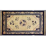 A CHINESE RUG, beige ground, with a central medallion depicting three carp. 7ft 6ins x 4ft 6ins.