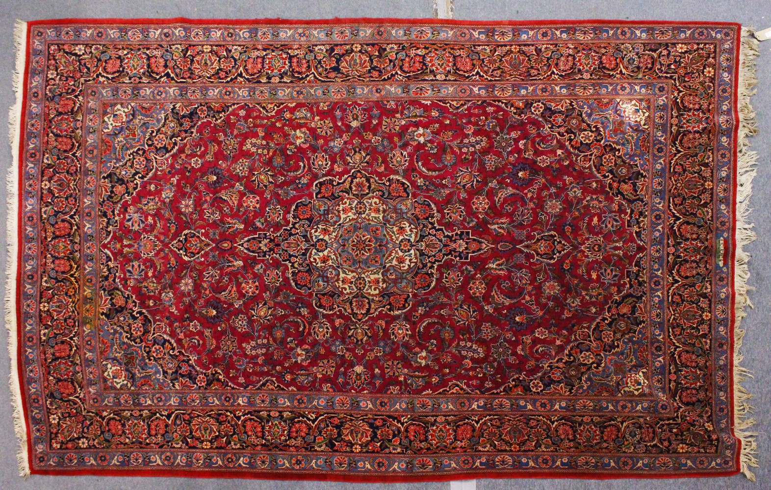 A GOOD PERSIAN CARPET, claret ground with stylised floral decoration, within a similar border.