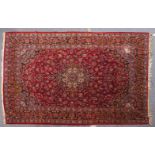 A GOOD PERSIAN CARPET, claret ground with stylised floral decoration, within a similar border.