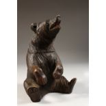 A CARVED BLACK FOREST SEATED BEAR TOBACCO BOX. 8ins high.