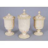 THREE SMALL EUROPEAN CARVED IVORY URN SHAPED PEPPERETTES. 2.5ins (2) and 3ins high.