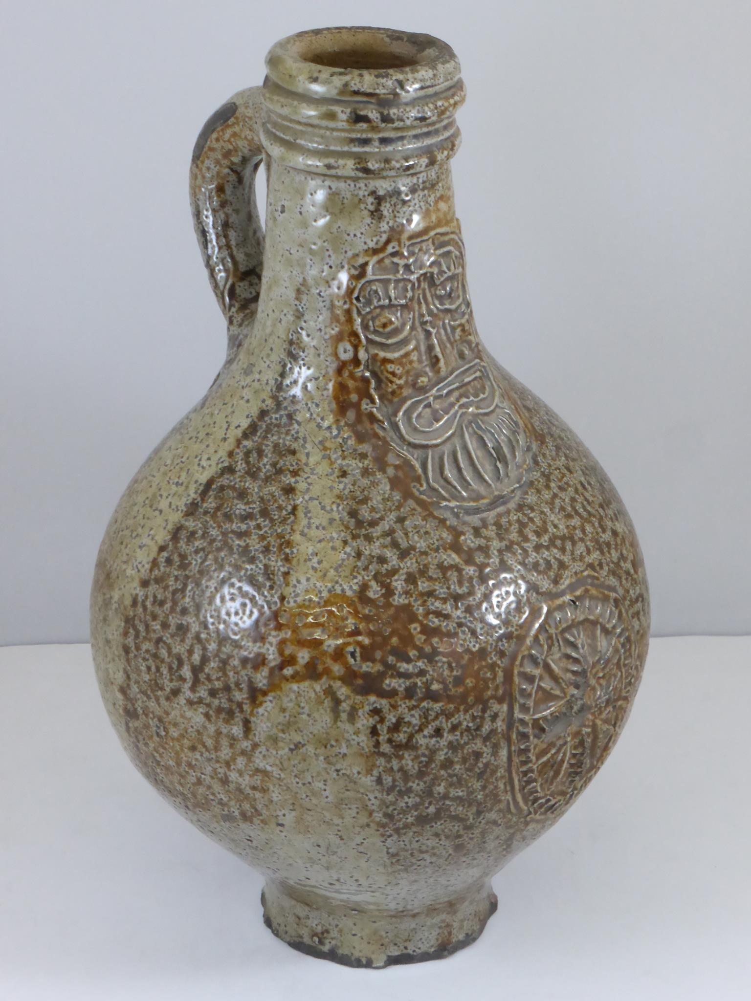 17TH CENTURY GERMAN SALT GLAZED BELLARMINE JUG WITH MASK AND CREST DECORATION, APPROX. 22 cm