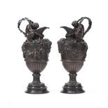 A pair of patinated bronze handled ewers