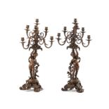 A pair of patinated metal candelabra