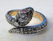 Tested as 18ct gold diamond snake ring with ruby eyes, central diamond 0.20 ct total weight 4.