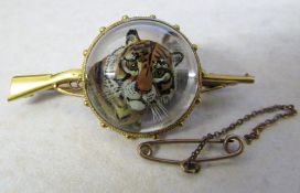 Tested as 9ct and 15ct gold reverse crystal intaglio brooch of a tiger with gun form bar (safety