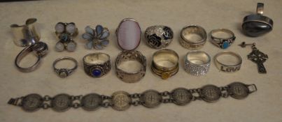 Approx 15 silver rings, three pence bracelet and a white metal Celtic cross earring,