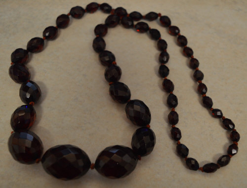 Graduated set of red facet cut cherry amber style beads