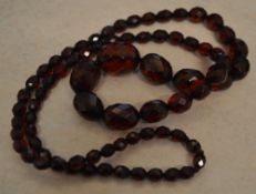 Graduated set of red facet cut cherry amber style beads