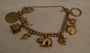 9ct gold charm bracelet including a 1911 full sovereign and various 9ct and unmarked yellow metal