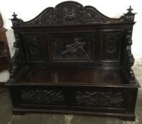 Large late 19th century oak settle with carved panel depicting a man fighting a lion