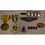 Reproduction militaria badges including a US Flight Surgeons Wings, Royal Navy badge, RWS badge,