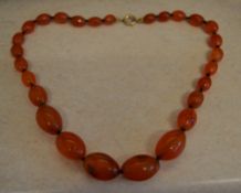 Graduated amber style glass bead necklace with a gold plated clasp