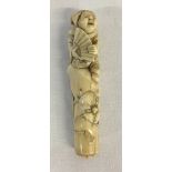 Japanese Meiji period carved ivory nesuke depicting an old woman seated on a rock with a fan