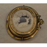 An ornate Victorian Pinchbeck swivel cameo brooch depicting a recumbent deer in a forest,