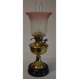 Brass oil lamp with ornate etched glass shade