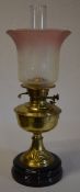 Brass oil lamp with ornate etched glass shade