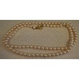 Simulated pearl necklace with an ornate gilt silver clasp and safety chain