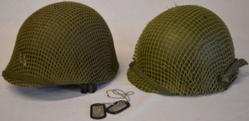 2 reproduction USA military M1 style helmets with netting including one marked Levior and a pair of