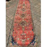 Large wash red ground persian runner with medallion design 375cm by 95cm