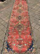 Large wash red ground persian runner with medallion design 375cm by 95cm