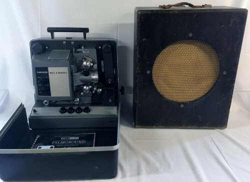 Bell & Howell film projector with cabinet speaker & film spool