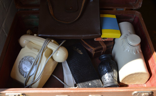 Suitcase of mixed items including retro rotary telephone,