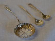 Silver strainer spoon and two small silver condiment spoons, total approx weight 0.