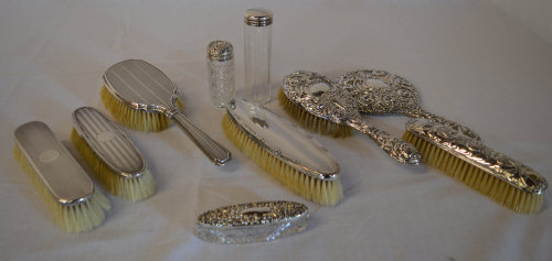 Various silver topped dressing table items, including hairbrushes,