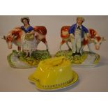 Pair of Staffordshire figures of farmer and wife with cows and a horse shoe butter dish